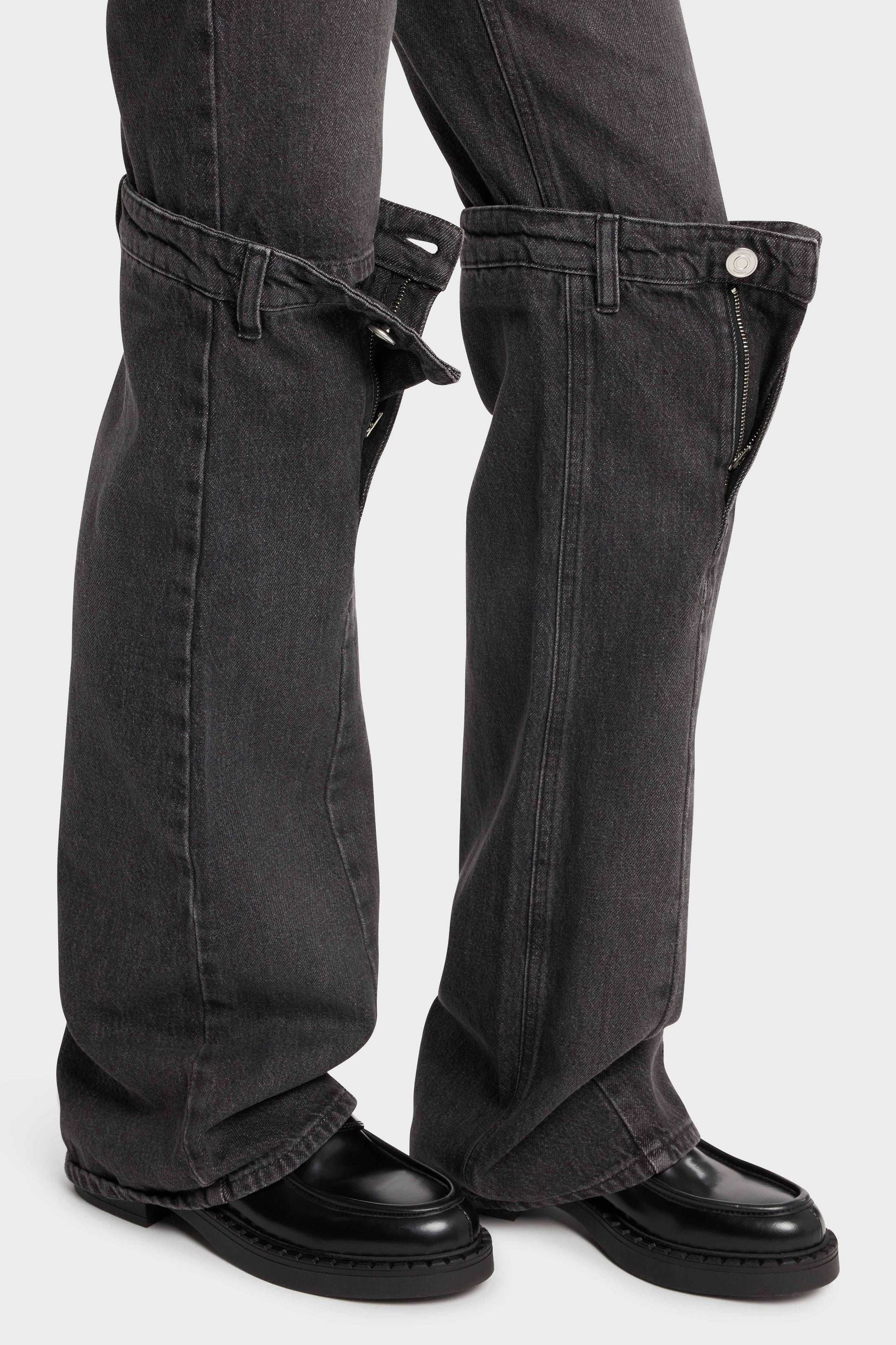Dark grey jeans with open knee engineering.